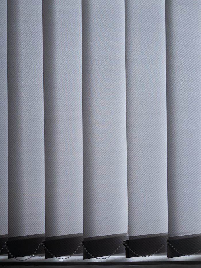 Close-up of modern vertical blinds in a contemporary office setting with natural light.